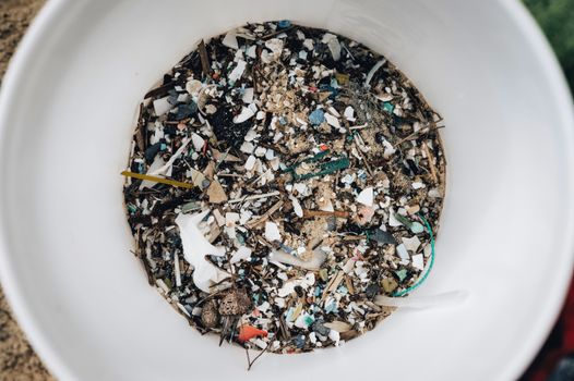 Glas water, plastic verpakking en stof in huis als illustratie bij microplastics en gezondheid in Oogophuizen