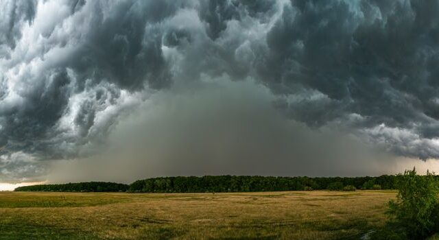 Storm Benjamin boven Oogophuizen met natte straten, waaiende bomen en een lege bushalte in de dorpskern