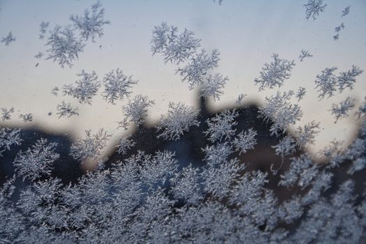 Sneeuwvlokjes op fietsen en stoep in de Regenboogstraat in Oogophuizen tijdens lichte sneeuwval